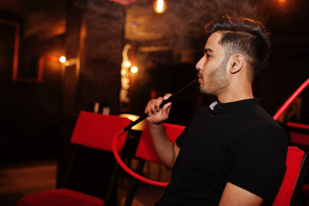 istock Asian man smoke hookah and having rest at lounge bar. 1140340361