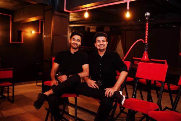 istock Two asian man smoke hookah and having rest at lounge bar. 1140340479