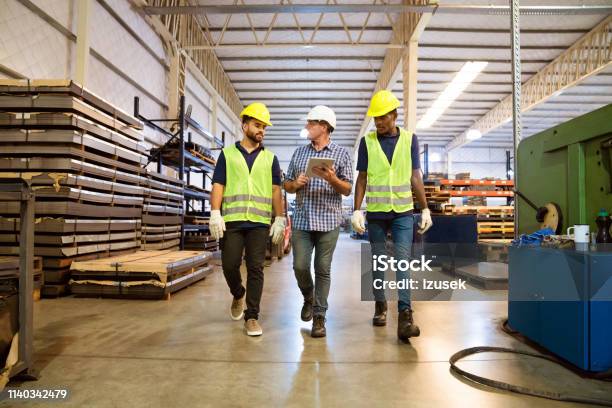 Foreman Discussing With Trainees In Factory Stock Photo - Download Image Now - Walking, Foreperson, Warehouse