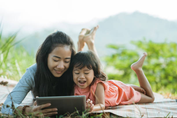 istock women and his daughter together watching digital tablet 1140342541