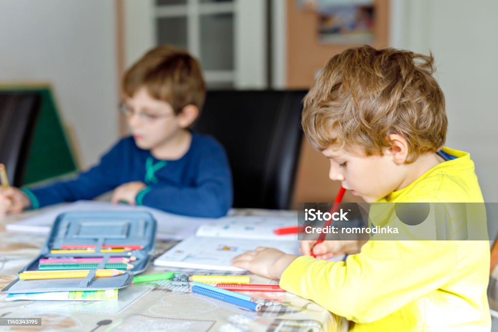 숙제를 만드는 집에서 두 작은 아이 소년 작은 집중 어린이 다채로운 연필 실내에 쓰기 초등 학교와 교육 형제 자매와 가장 친한 ...