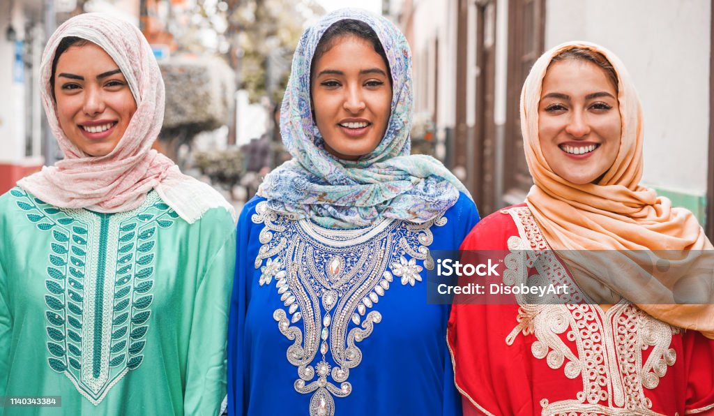 Portrait of arabian girls outdoor in city street - Young islamic women smiling on camera - Youth, friendship, religion and culture concept - Focus on faces Women Stock Photo