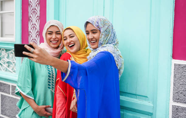 Happy arabian friends using smartphone for making selfie story on social network app - Young girls with hijab having fun with new trend technology - Friendship concept - Focus on right girl face Happy arabian friends using smartphone for making selfie story on social network app - Young girls with hijab having fun with new trend technology - Friendship concept - Focus on right girl face moroccan girl stock pictures, royalty-free photos & images