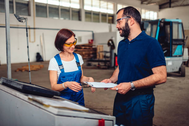 istock Woman CNC Machine Operator consulting with Engineer 1140346054