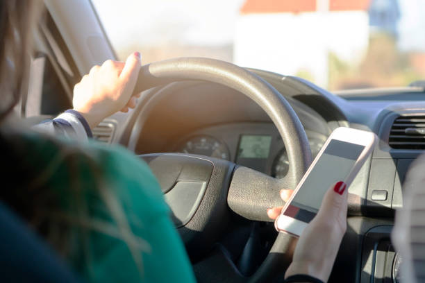 istock Woman driving a car and using a mobile phone with map GPS navigation 1140346368