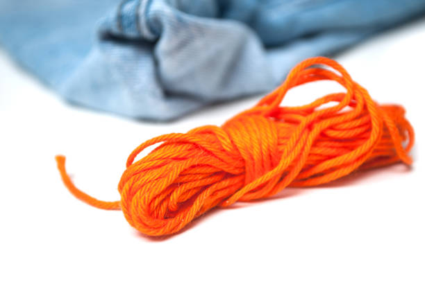 istock orange cotton threads on white table on blue jeans background 1140347260