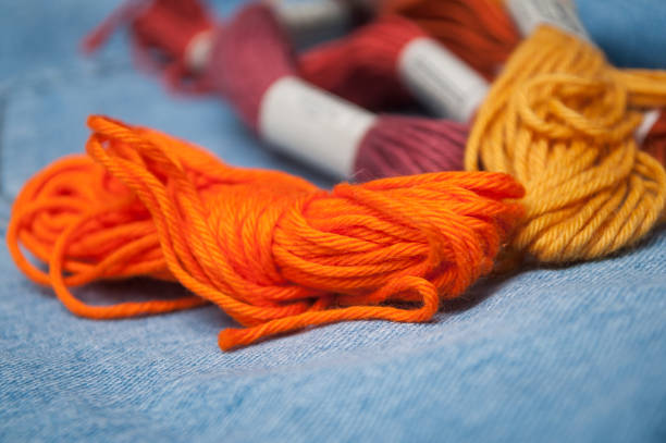 istock colorful cotton threads on blue jeans  background 1140347267