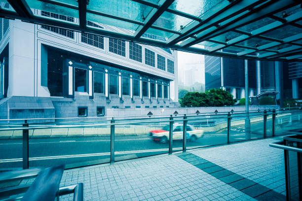 Close up photo of a blue painted wall with a metal railing beside an urban street