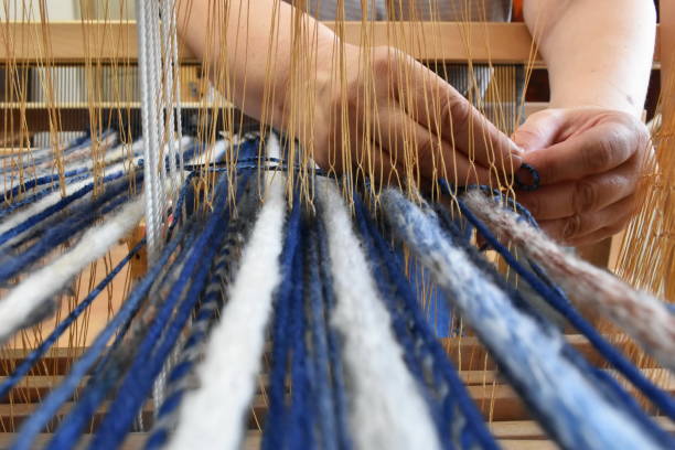 istock Woman's hands  weaving on a  loom 1140348185