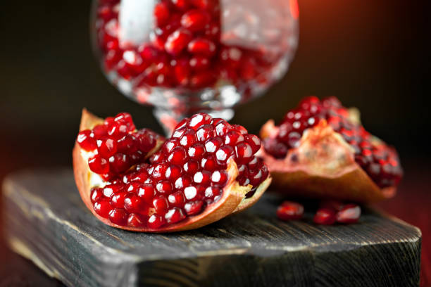 istock Ripe pomegranate fruit on a old black wooden vintage background. Selective focus. 1140355280
