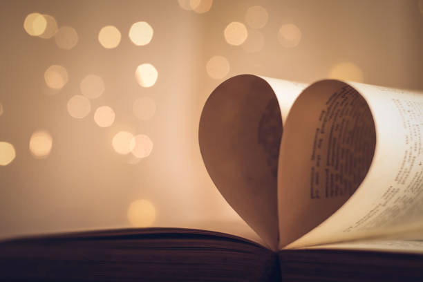 istock Book pages folded into a heart shape with blurred light bokeh background 1140363015