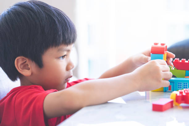 istock Asian boy stacking Toy blocks on a living room table 1140363127