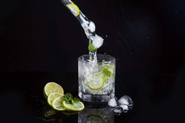 istock Summer cocktail mojito with splash on black background. 1140363322