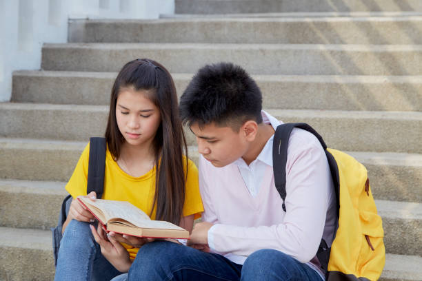 istock Two students guy and girl studying stairs in park 1140363458