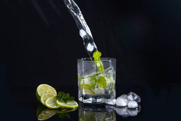 istock Summer cocktail mojito with splash on black background. 1140363760