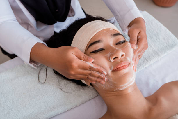 istock Young woman enjoying massage with mask cream 1140371727