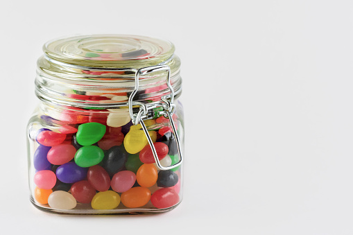 A glass jar filled with colorful jelly beans.