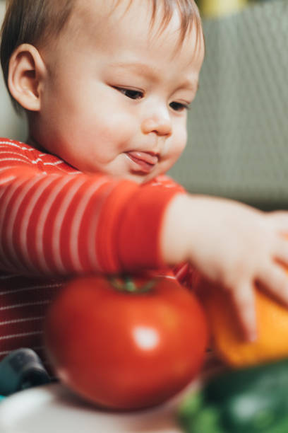 istock Baby boy playing with fresh fruit and vegetables 1140374714