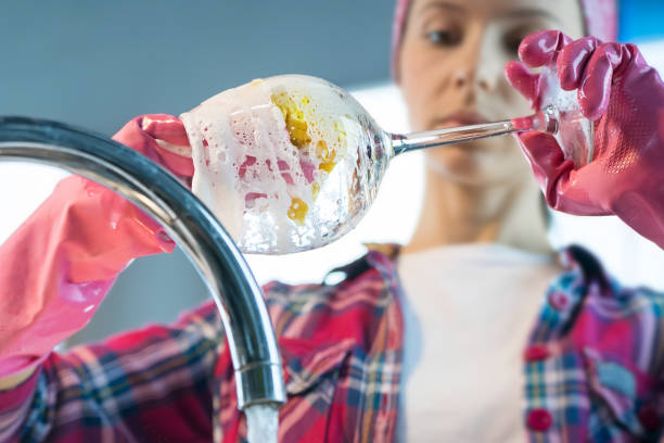 istock Woman washes wineglass in kitchen 1140376028