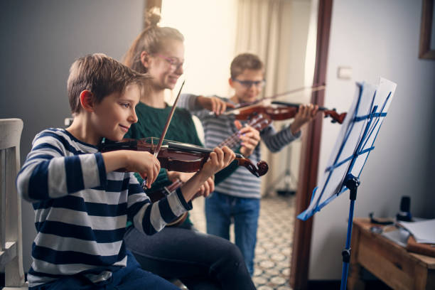 los niños ensayando música juntos - violin family fotografías e imágenes de stock