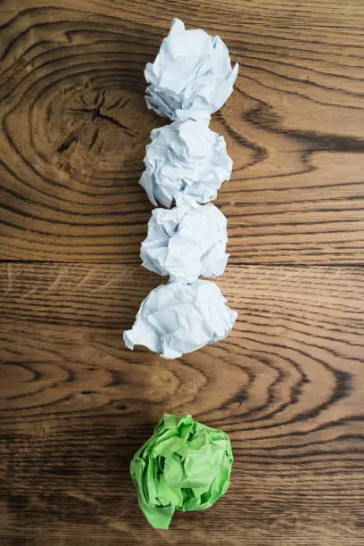 crumpled paper symbolizing different solutions forming an exclamation-mark