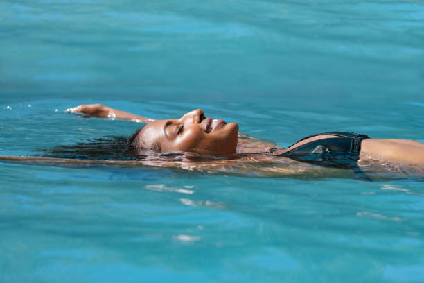 zrelaksowana kobieta unosząca się w basenie - resort swimming pool swimming swimming pool women zdjęcia i obrazy z banku zdjęć