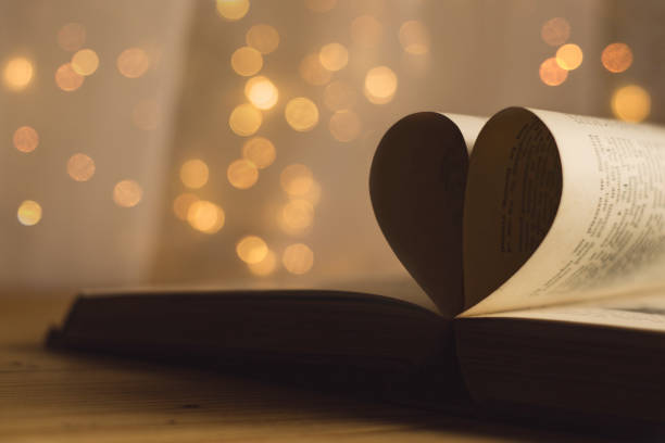 istock Book pages folded into a heart shape with blurred light bokeh background 1140380801