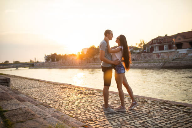 istock Couple in love standing by the river on sunset 1140384236