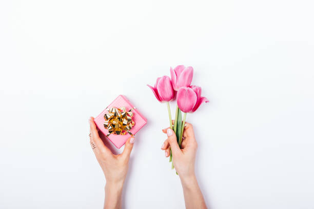 istock Woman's hands holding small pink gift box with golden bow 1140384915