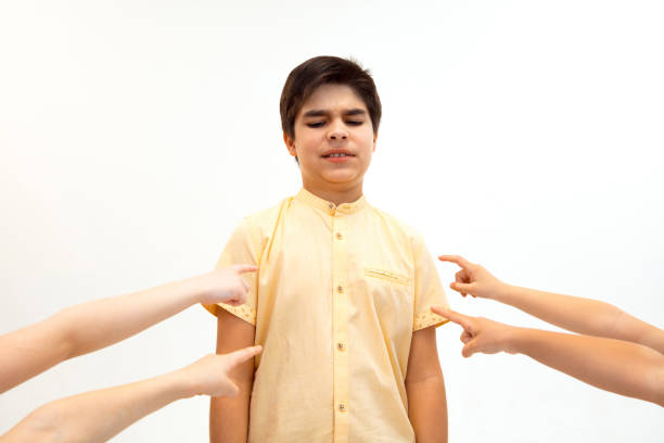 rapaz pequeno que está sozinho e que sofre um ato do bullying. - bullying child teasing little boys - fotografias e filmes do acervo