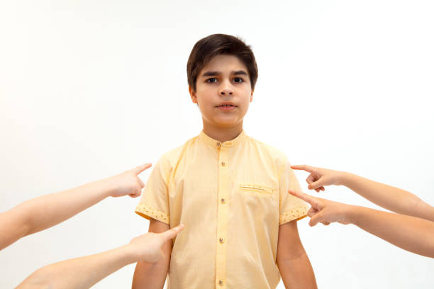 маленький мальчик, стоящий один и страдающий актом издевательств. - bullying child teasing little boys стоковые фото и изображения