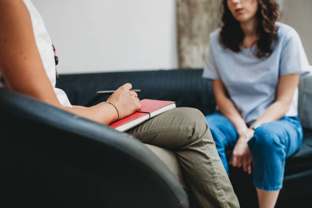 Psychotherapy session, woman talking to his psychologist in the studio Psychotherapy session, woman talking to his psychologist in the studio psychotherapy stock pictures, royalty-free photos & images