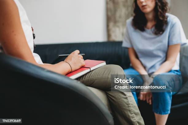 Psychotherapy Session Woman Talking To His Psychologist In The Studio Stock Photo - Download Image Now