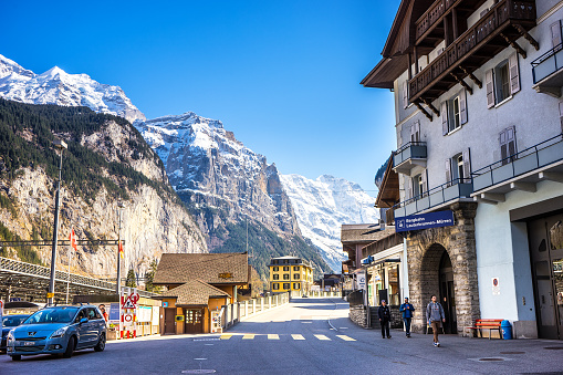 Lauterbrunnen, Switzerland - April 10, 2016 : Lauterbrunnen is a village located in  U-shaped valley. A stunning view of the village are framed by high cliff and snow mountain in background.