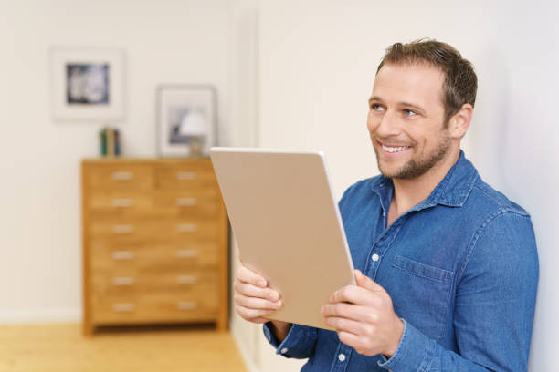 istock Man smiling with big tablet in his hands 1140395978