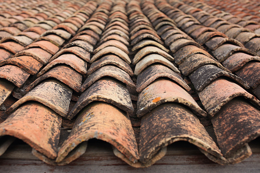 Good texture of old artisanal tiled roof on the brick house