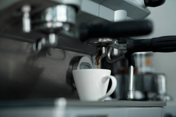 istock Coffee machinne pours freshly brewed coffee in white cup. 1140405471