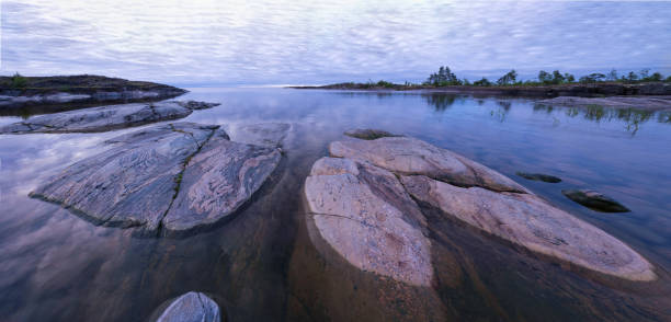 istock Landscape panorama with sunrise at rocky lake coastline 1140407194