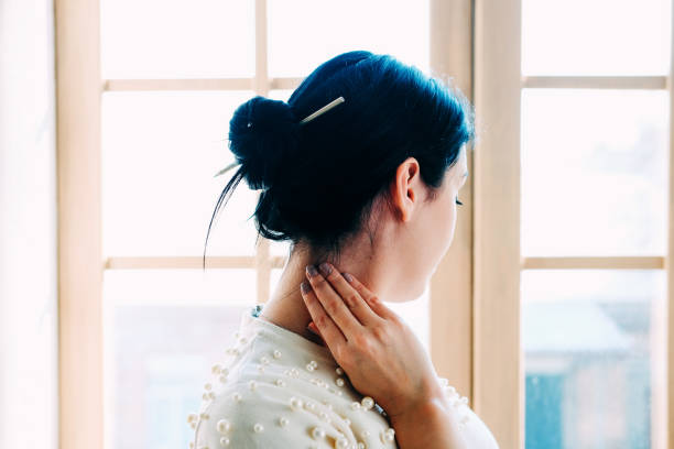 jeune femme d’étudiant dans la classe avec un crayon dans le chignon de cheveu. vue de l’arrière. - hair bun hairstyle women hair back photos et images de collection