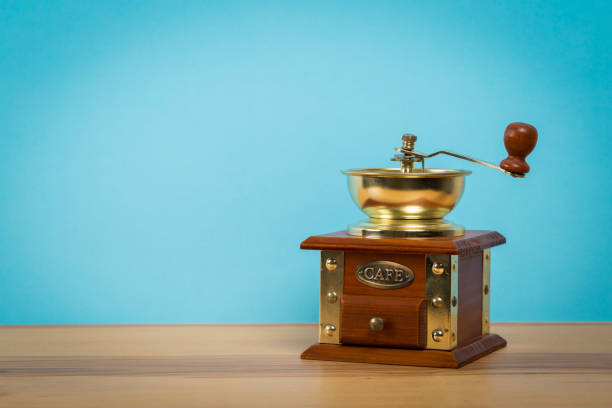 istock Vintage old manual coffee grinder on wooden table with color wall background 1140407704