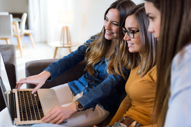 istock Three happy beautiful women using laptop at home. 1140411162