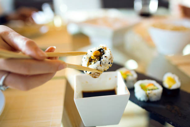 istock Woman's hand picking up sushi with chopsticks. 1140411674