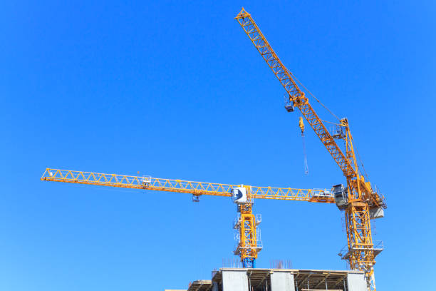 istock Construction cranes and the top of a skyscraper 1140411849