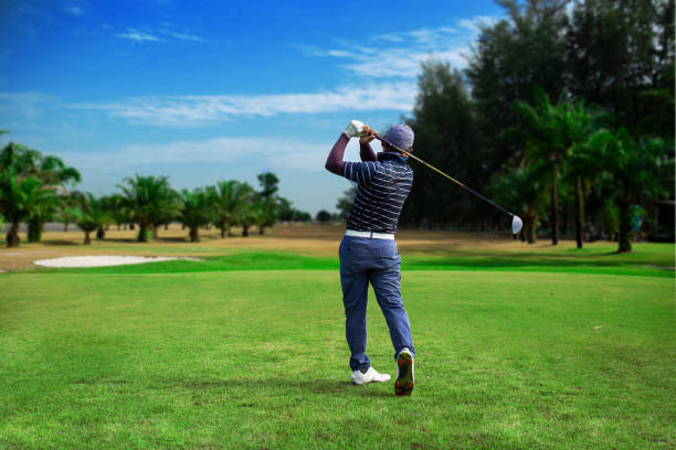 golfer trifft golf schuss mit club auf dem parcours vintage-farbton, man spielt golf auf einem golfplatz in der sonne, golfer getroffen schwungvollen golfplatz im sommer. - golfschwung stock-fotos und bilder