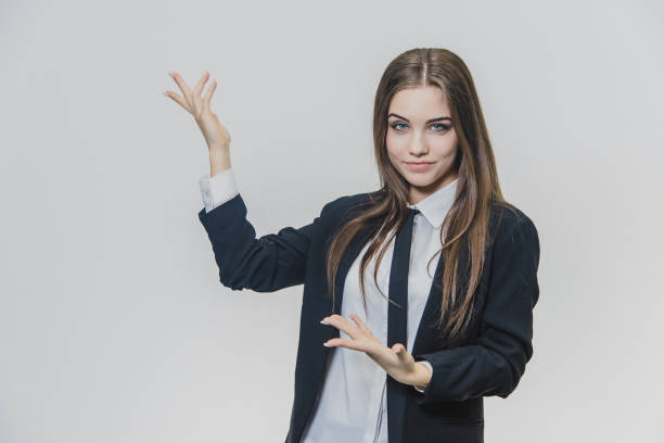 istock Serious thoughtful and thin smiled, brown-haired businesswoman is thinking while showing something with her fingers. 1140421021