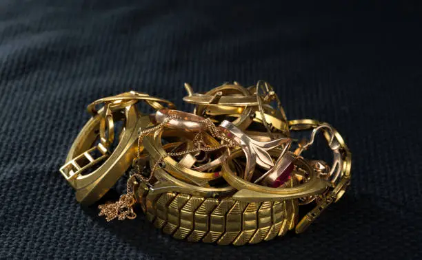 Photo of A scrap of gold. Old and broken jewelry, watches of gold and gold-plated