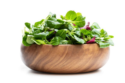 Mixed  salad leaves in wooden bowl isolated on white