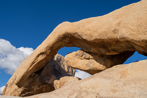 Beautiful view of Arch Rock in Joshua Tree National Park. Late Afternoon sunshine against blue sky
