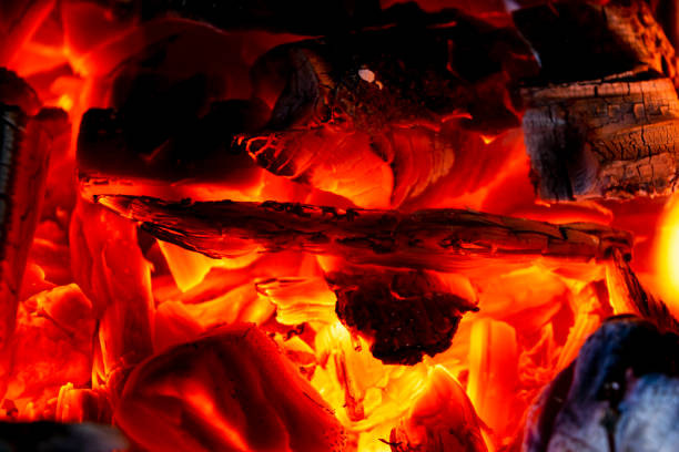 Burning firewood in the fireplace close up, BBQ fire, charcoal background. Charcoal fire with sparks. Fire background. Close up