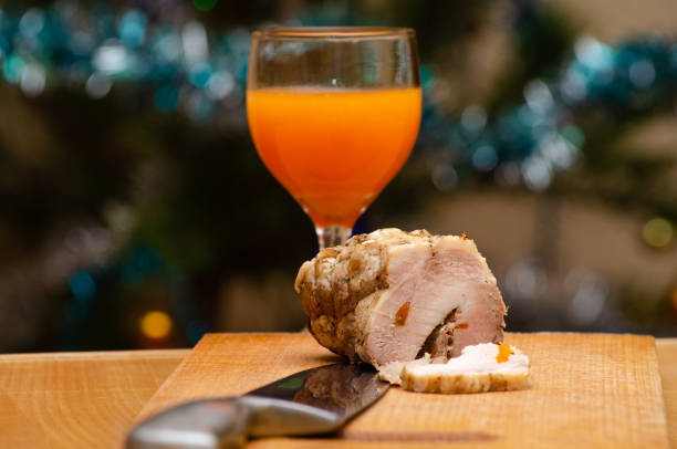 Rolled belly pork joint with spices ready for roasting on a cutting board,isolated on white with cliiping path.